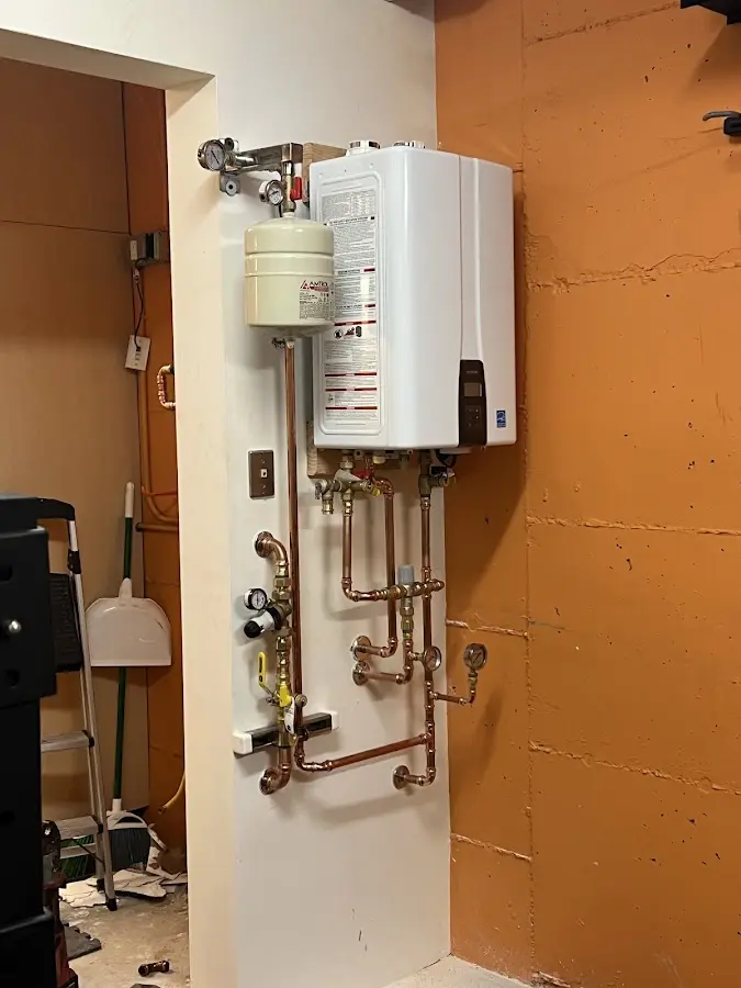 Plumbing technician inspecting water heater connections in Summerfield